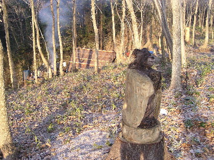 切り株を利用した熊の彫刻と炭焼き小屋